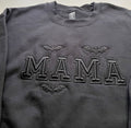 Black crewneck sweatshirt with black embroidered MAMA varsity letters and three bats